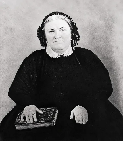 Black-and-white portrait of Catherine Johnson Lott, seated in a dark dress and lace cap, her hand resting on a book