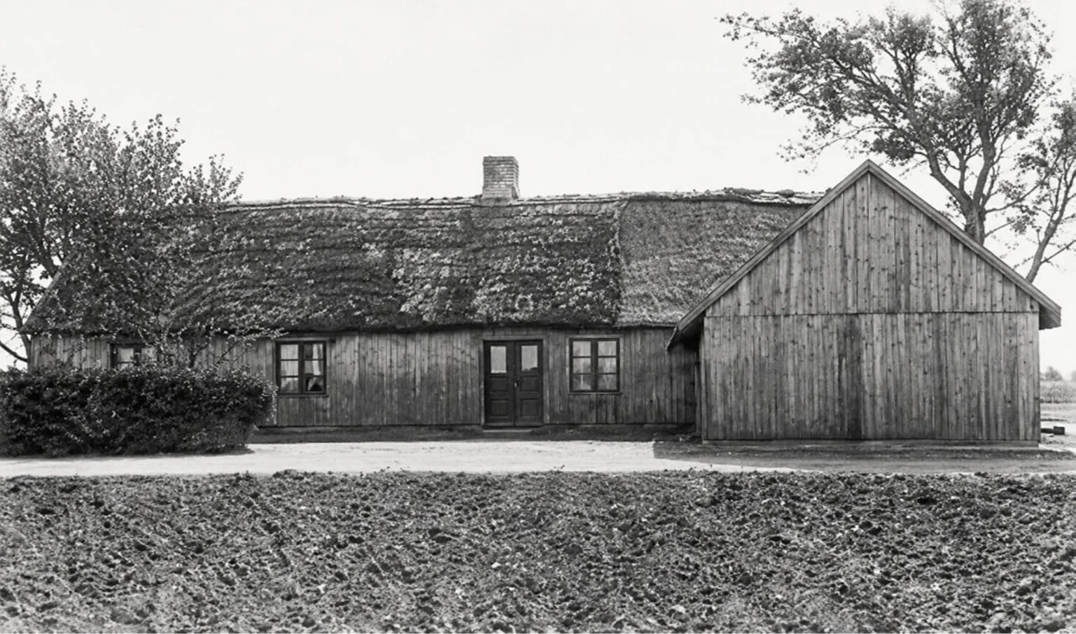 Old photograph of the Olson family home in Sweden, a modest house with outbuildings, where Annie Olsson was born in 1880