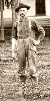 what-happened-to-the-family-farm-4 Faded photograph of J. P. Mason, a mustached man in a hat and work clothes standing with one hand on his hip