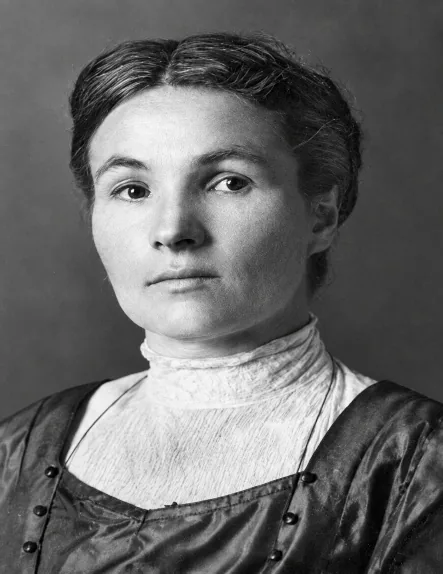 Black-and-white portrait of Annie Olsson Jepson, a young woman with dark hair parted in the middle, wearing a high-collared white blouse